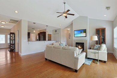 Living room featuring a tile fireplace, ceiling fa