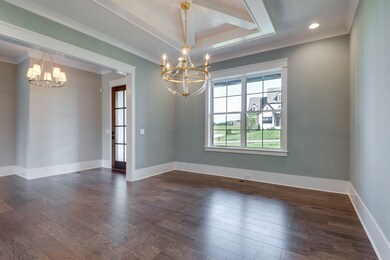 The dining room situated just to the left of the entry foyer. Measures 13x15. Double windows  allow natural light to flow through and the  modern shiplap coffered ceiling adds character and comfortable livability to this formal dining area.