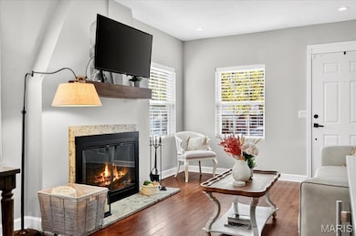 Living area featuring hardwood / wood-style floors, a high end fireplace, and recessed lighting