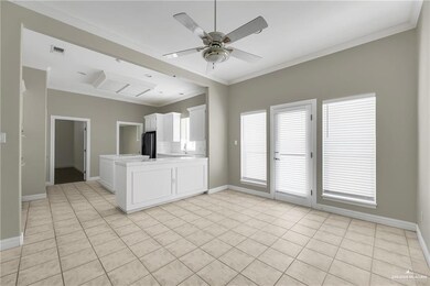 Kitchen featuring white cabinets, a peninsula, light countertops, ornamental molding, and light tile patterned floors