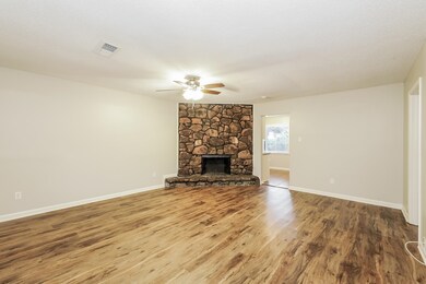 Unfurnished living room with ceiling fan, a stone 