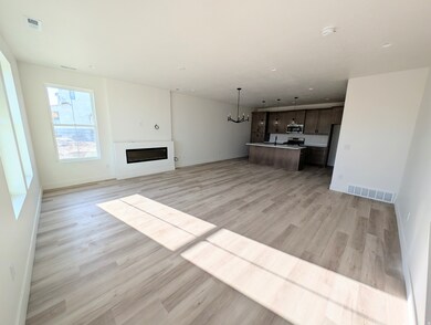 Unfurnished living room with light wood-type flooring, a chandelier, and a fireplace