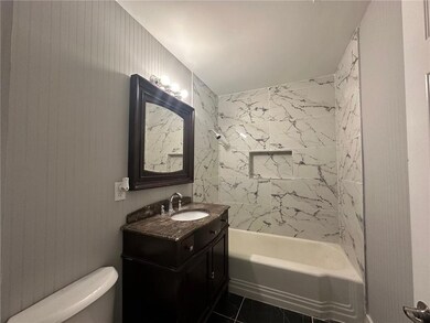Bathroom featuring vanity, toilet, and  shower combination