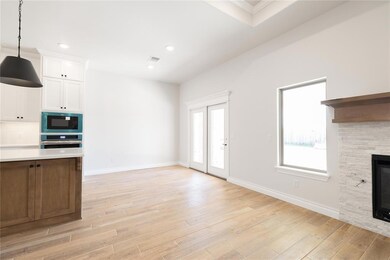 Unfurnished living room featuring light wood-style floors, a stone fireplace, baseboards, and recessed lighting