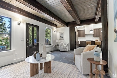 Tiled living room with baseboards and beamed ceiling