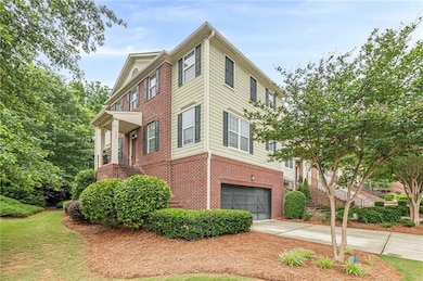 View of property exterior featuring brick siding, an attached garage, and driveway