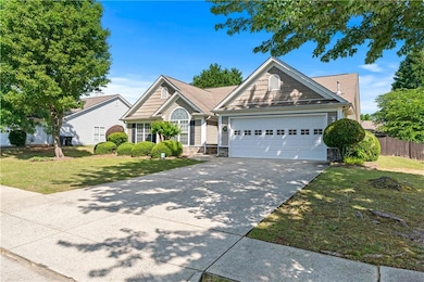 View of front of home with an attached garage, dri