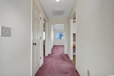 Corridor featuring carpet and baseboards