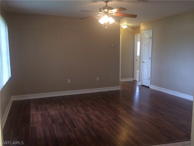 As you enter, the living room to your left features laminate flooring, wide baseboards, ceiling fan and natural lighting from the front windows.
