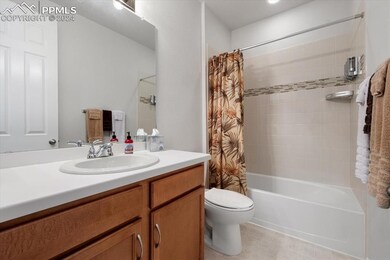 Full bathroom with tile floors, shower / bath combination with curtain, toilet, and oversized vanity