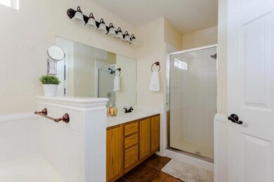 Bathroom with a shower stall, vanity, tile patter