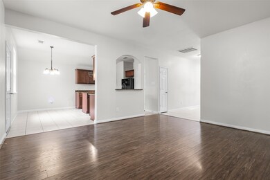 Unfurnished living room with ceiling fan, light wood-style flooring, arched walkways, and a chandelier