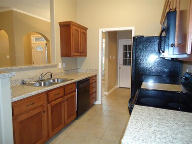 Another view of the efficient kitchen, nice stylish countertops, breakfast bar, tile floor