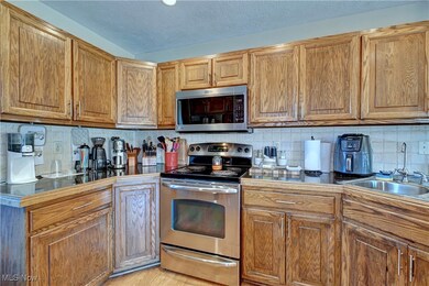 Kitchen with stainless steel appliances, brown cabinets, backsplash, and a textured ceiling