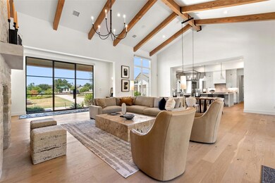 Living room featuring a chandelier, high vaulted ceiling, beamed ceiling, light wood-style floors, and recessed lighting
