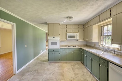 Kitchen featuring a textured ceiling, light counte