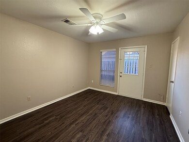 First floor bedroom with luxury vinyl plank flooring and door to the patio.