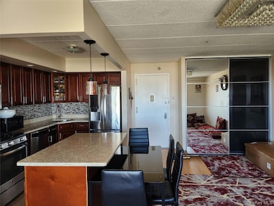 Kitchen with stainless steel appliances, hanging light fixtures, tasteful backsplash, glass insert cabinets, and a kitchen island