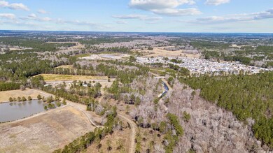 Aerial view of property and surrounding area featuring a forest