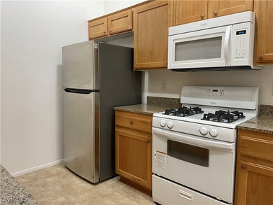 Kitchen with white appliances, brown cabinetry, st