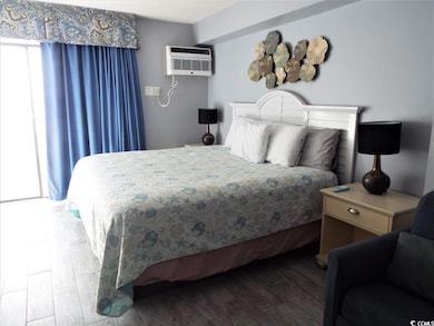 Bedroom featuring a wall mounted air conditioner a