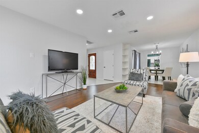 Step through the solid wood & leaded glass front door and to the left, you'll find the main living space finished with neutral paint, recessed lighting, and handsome wood-look laminate flooring.
