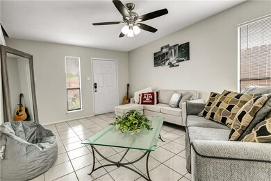 Living room featuring ceiling fan and light tile p