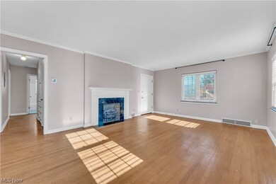 Unfurnished living room with light hardwood / wood-style flooring, a premium fireplace, and ornamental molding