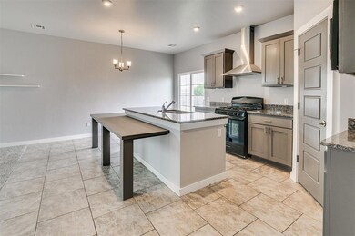 Kitchen with a sink, visible vents, wall chimney r