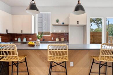 Kitchen with a kitchen breakfast bar, tasteful backsplash, open shelves, and dark countertops