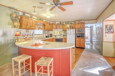Kitchen featuring white fridge, wood walls, range 