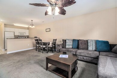 Living area with ceiling fan, light colored carpet