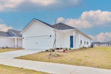 View of front of property with cooling unit, board