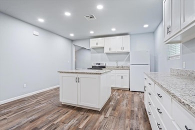 Kitchen featuring freestanding refrigerator, stai