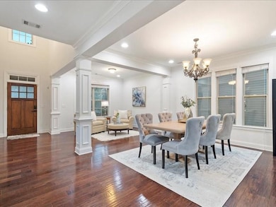 Dining area with decorative columns, a chandelier, ornamental molding, dark wood-type flooring, and recessed lighting