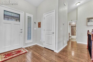 Entryway with wood-type flooring and a textured ce