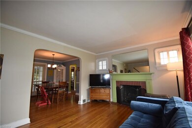 Hardwood floored living room featuring crown moldi