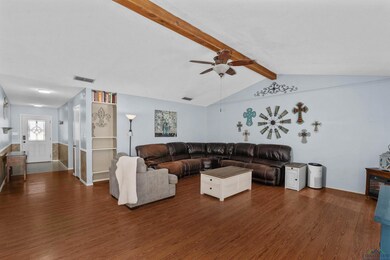 Living room with ceiling fan, vaulted ceiling with