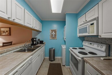 Kitchen has updated cabinets, ceramic tile floors and counter tops