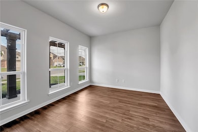 Empty room featuring wood finished floors and baseboards