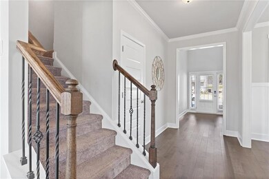 Foyer with dark wood-type flooring, baseboards, st