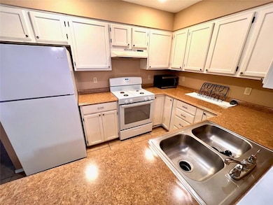 Kitchen featuring white appliances, under cabinet