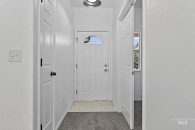 Doorway to outside with carpet floors and baseboards
