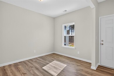 Spare room featuring light wood-style flooring and baseboards