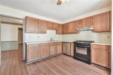 Kitchen featuring a sink, light countertops, black