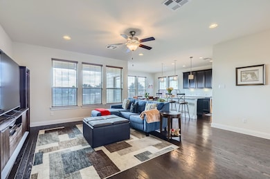 Living area with ceiling fan, dark wood-type floo