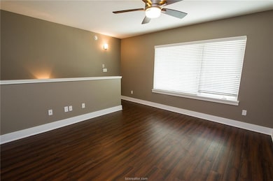 Empty room with dark wood finished floors, baseboa