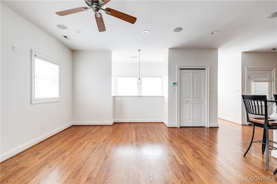 Unfurnished living room with a ceiling fan, light