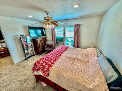 Carpeted bedroom featuring a ceiling fan, a textur