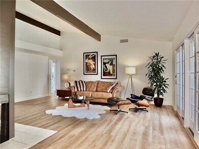 The living room has a vaulted and beamed ceiling and is flooded with natural light.